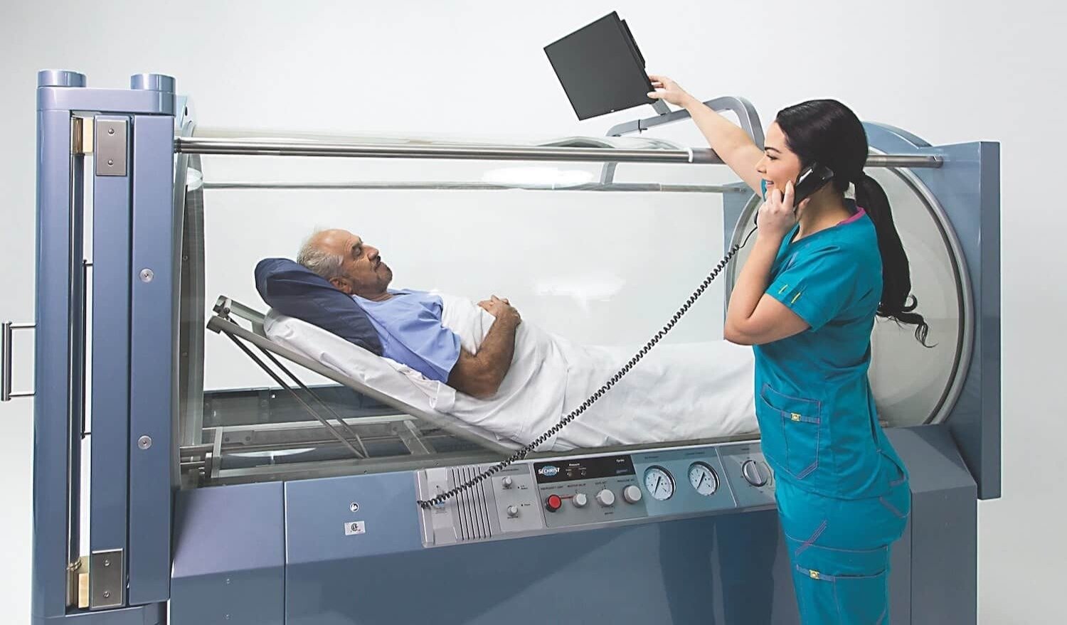 Patient receiving hyperbaric oxygen therapy in a medical-grade monoplace chamber, monitored by clinical staff